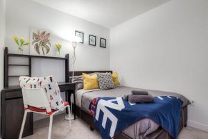 ein Schlafzimmer mit einem Bett, einem Schreibtisch und einem Stuhl in der Unterkunft Modern 3Br Condo with Balcony Downtown Toronto in Toronto