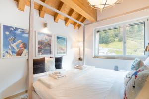 a bedroom with a large bed and a window at Swiss Family Chalet in Andermatt