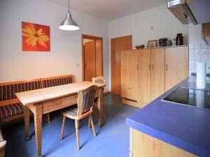 a kitchen with a wooden table and some chairs at Holiday farm situated next to the Kellerwald-Edersee national park with a sunbathing lawn in Bad Wildungen