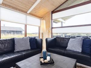 ロンストラップにある8 person holiday home in Hjørring-By Traumのリビングルーム(黒革の家具、大きな窓付)