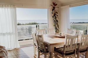 a dining room with a table and chairs and a large window at Sailor's Catch in Hokitika