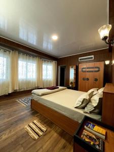 a bedroom with a large bed and a wooden floor at Lemos Cafe and Homestay in Kurseong