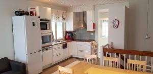 a kitchen with white cabinets and a white refrigerator at A1 Snow Angels Visit Levi in Levi