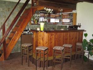 a bar with stools in a room with a staircase at Penzion Nevcehle in Urbanov