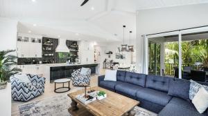 een woonkamer en een keuken met een blauwe bank bij Oar House in Anna Maria