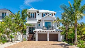 een wit huis met palmbomen ervoor bij Oar House in Anna Maria