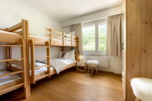 a small room with bunk beds and a window at Casa Olympia in Andermatt