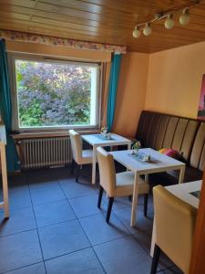 a restaurant with two tables and a window at Famile Hotel Kameleon in Olsberg
