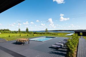a patio with a pool and chairs and a table at Villa Rantala in Kuortane