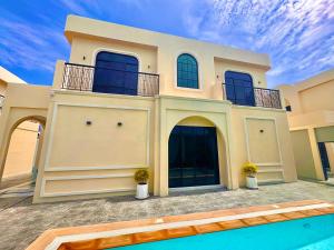 a house with a swimming pool in front of it at FLEX Pool Villa in Pattaya Central