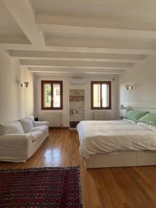 a large bedroom with a bed and a couch at Borgo Cavour Santi40 in Treviso +11 photos