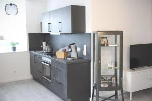 a kitchen with a stove and a refrigerator at Ferienwohnung Kleine Auszeit in Schweich