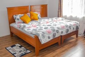 a bed with several pillows on it in a room at Osim Apartment in Arusha