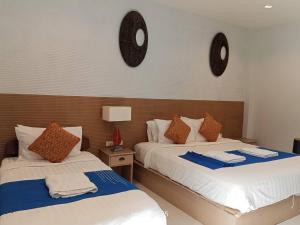 two beds in a room with two mirrors on the wall at PaKrongCheep Homestay in Ban Muang Mai