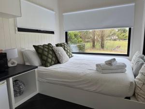 BurradooにあるBantry Tiny Homeの窓のある白いベッドのある寝室