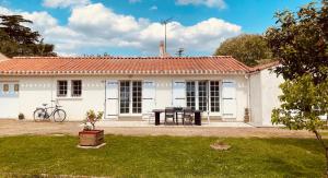 a white house with a table in front of it at Sérénité Marais-Océan in Longeville-sur-Mer