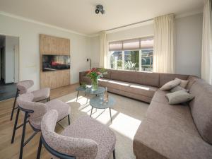 a living room with a couch and chairs at Groepsaccommodatie met hottub en sauna | 18 personen in Neede