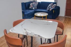 a marble table in a living room with a couch at Osim Apartment in Arusha