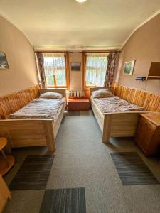 two beds in a small room with windows at Horská chata Amor in Pec pod Sněžkou