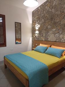 a bedroom with a bed with a stone wall at Villa REBECCA in Solanas