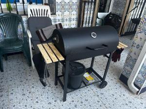 a barbecue grill sitting on a table next to a chair at "Casa Grande"de Como En Casa in Don Benito