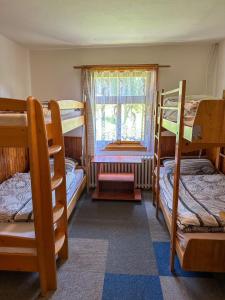a room with four bunk beds and a window at Horská chata Amor in Pec pod Sněžkou