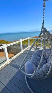 a hammock on a deck with a view of the ocean at Anchor's Drop in Blue Anchor