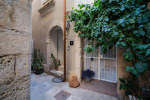 an entrance to a building with a door and a tree at Naiadi Giudecca in Siracusa