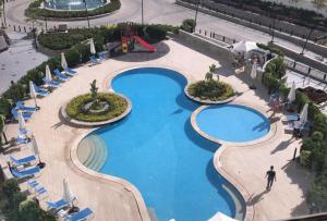 an overhead view of a swimming pool with chairs and umbrellas at elegant hotel studio Porto New Cairo pool access in Cairo