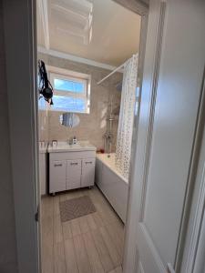 a bathroom with a tub and a sink and a mirror at Karakol Comfort Apartments in Karakol +22 photos