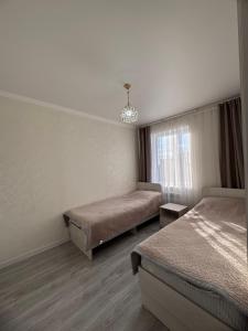 a hotel room with two beds and a window at Karakol Comfort Apartments in Karakol