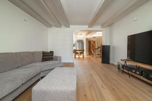 een woonkamer met een bank en een flatscreen-tv bij Spacious 3 BDR apartment in Old Town in Vilnius