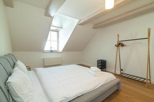 een slaapkamer met een groot wit bed op een zolder bij Spacious 3 BDR apartment in Old Town in Vilnius