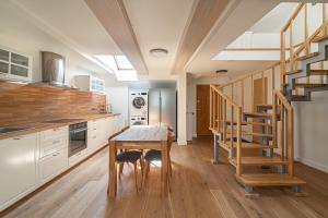 een keuken met een houten tafel en een trap bij Spacious 3 BDR apartment in Old Town in Vilnius
