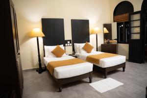 a hotel room with two beds and two lamps at Heritage Dambulla By Ceylon Hotels Corporation in Dambulla