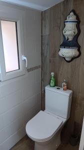 a bathroom with a white toilet and a window at Gite bleu in Aizenay