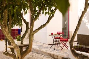 a table and chairs in a courtyard with trees at Spot na Serra in Loulé