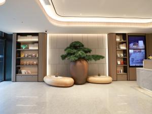 a large vase with a tree in a room at JI Hotel Beijing Yanqing Tower Wanda Plaza in Yanqing