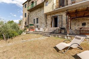 a pair of white chairs sitting outside of a building at Margherita's Home in Chianti in San Donato in Poggio