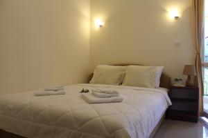 a bedroom with a white bed with towels on it at Swiss Residence Montenegro in Herceg-Novi