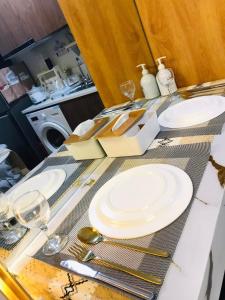 a table with white plates and silverware on it at ART Dreamplace 1BR Studio Pool WiFi Netflix in Suba