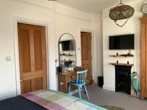 a bedroom with a bed and a desk with a television at Sea Spirit Eco Guest House in Exmouth +34 photos