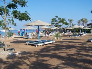 een strand met stoelen en parasols en mensen op het strand bij Eiffel Hotel Hurghada in Hurghada