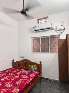 um quarto com uma cama, uma janela e uma ventoinha em sharika cafe home stay em Auroville