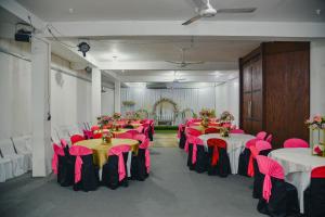 a room filled with tables and chairs with pink and yellow tables at Relax - Budget Rooms in Batapola in Batapola