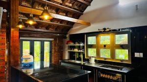 a kitchen with a counter and two windows in it at Cát Tiên Garden Homestay 