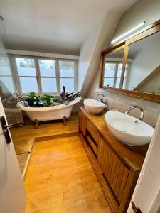 a bathroom with two sinks and a bath tub at La Chanterelle in Wavre
