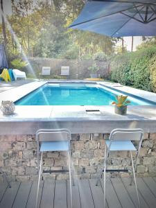 a swimming pool with two chairs and an umbrella at La Chanterelle in Wavre