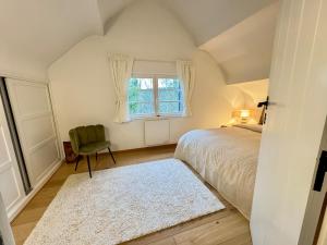 a bedroom with a bed and a chair and a window at La Chanterelle in Wavre +19 photos