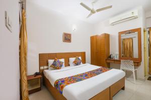 een slaapkamer met een bed en een bureau erin bij FabHotel RKH Skylink Residency in Chennai